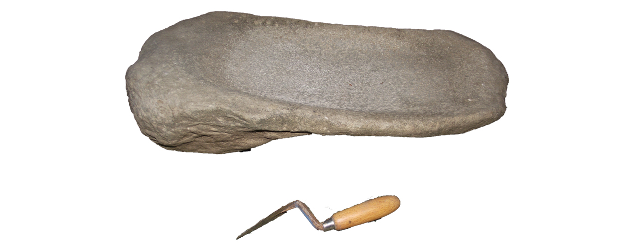 Saddle quern, with trowel as scale